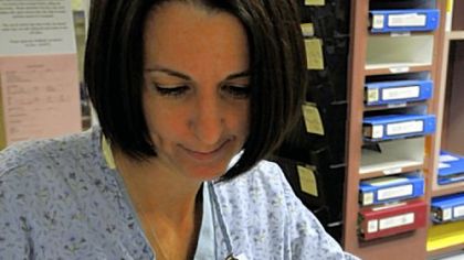 Post-Gazette
Donna Koss-Bradish, R.N., wears a Vocera badge while filling out paperwork at a nurses station.
