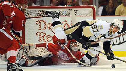 Red Wings goalie Chris Osgood makes a save on Sidney Crosby last night.