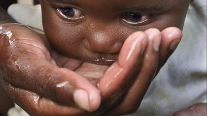 HARARE, Zimbabwe -- A baby drinks water from her mother's hand. European Union nations moved to tighten sanctions against Zimbabwe''s government, Dec. 8, and stood united in calling for the country's authoritarian leader, Robert Mugabe, to "step down." The move was to protest the deteriorating humanitarian conditions, including a cholera outbreak that is claiming thousands of lives.