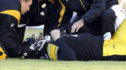 Steelers coach Mike Tomlin watches as trainers tend to quarterback Ben Roethlisberger after he was injured in the second quarter against the Browns yesterday at Heinz Field. Roethlisberger was later diagnosed with a concussion.