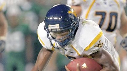 West Virginia's Pat White is tripped up by South Florida's Jerome Murphy in September 2007.  The Bulls won, 21-13.