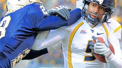 West Virginia quarterback Pat White is pushed out of bounds by the Panthers' Eric Thatcher yesterday.