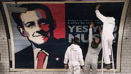 PARIS -- Members of Greenpeace cover a subway station wall with a poster depicting French President Nicolas Sarkozy. The image was inspired by an iconic Barack Obama election image, designed by U.S. graphic artist, Shepard Fairey. It reads, "Reduce 30% of greenhouse gas emissions in Europe? Yes you must!".
