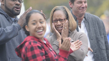 Frank Slaughter, Tayana Slaughter and Tracy Slaughter react to their new home as "Extreme Makeover: Home Edition" in front of host Ty Pennington, right.