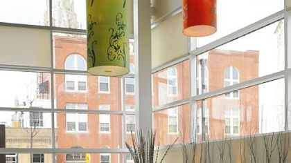 The restaurant's interior features bright white walls, dark wooden tables and colorful lanterns.
