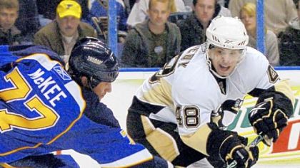Tyler Kennedy slides a pass around the Blues' Jay McKee last night in St. Louis.