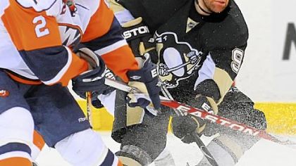 Pascal Dupuis fights for the puck against the Islanders in the third period last night at Mellon Arena. Dupuis recorded his first NHL hat trick in the game.
