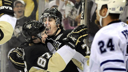 Sidney Crosby, left, is congratulated by teammate Evgeni Malkin after scoring his 100th career goal in the third period last night at Mellon Arena.