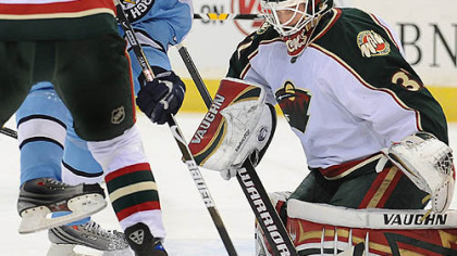 Evgeni Malkin battles for a loose puck with the Wild's Kim Johnsson in front of Wild goalie Niklas Backstrom last night at Mellon Arena.