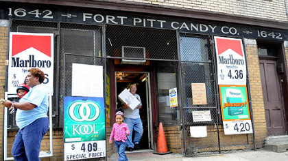 Bill McCoy of McKeesport, carries an order to the car for Zena Stafford, Allentown (with granddaughter, Zena, 2, in tow) at the Fort Pitt Candy Company in the Strip.