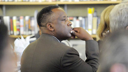 Eric Mann, CEO of the YMCA of Greater Pittsburgh, listens as Homestead's Montae Russell reads August Wilson during the Carnegie Library of Pittsburgh Hill District library grand opening.