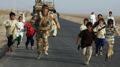 BASRA -- Children from the village of Al Houta try to race with British servicemen as they visit to recruit local labor and engage with the village sheikh.