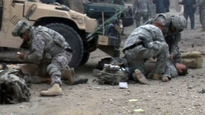 PUL-E-KHUMRI, Afghanistan -- An image taken from a video shows US soldiers giving first aid to the victims of  a suicide attack at a police station in the capital of Baghlan province, north of  Kabul, Oct. 27. A suicide bomber wearing a police uniform blew himself up inside a police station killing two American soldiers and wounding five other people, officials said.