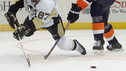 Sidney Crosby passes the puck in front of the Islanders' Andy Sutton in the third period.