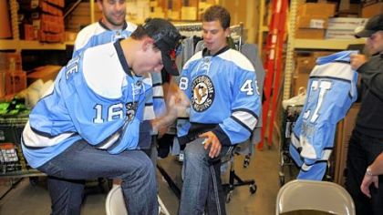 Penguins players Paul Bissonnette, front, Eric Godard, left, Tyler Kennedy and Alex Goligoski  joke around while posing for photos after an event at Dick's Sporting Goods in Robinson showcasing the blue "throwback" Penguins hockey jerseys.