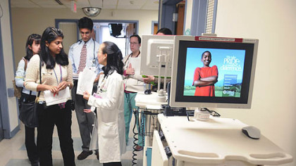 After examining a patient Dr. Sylvia Choi, center, talks with intern Ruchika Goel at Children's Hospital of Pittsburgh of UPMC. To the right are two of the computers used for record keeping.