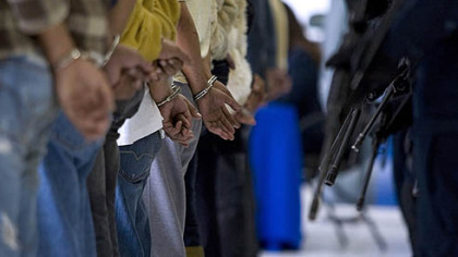 MEXICO CITY -- Policemen guard 15 members of the Beltran Leyva brothers cartel as they are presented to the press. Most of them are Colombian and were captured in Mexico City.