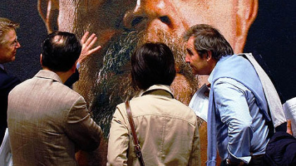 MIAMI BEACH -- People study a painting by Chuck Close, at Art Basel Miami Beach. The event is the sister event of Switzerland's Art Basel.