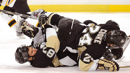 Matt Cooke collides with Sidney Crosby in front of Bruins goalie Tim Thomas in the third period last night.