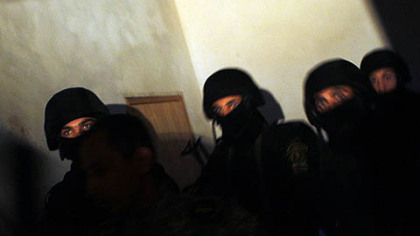 PALESTINE -- Palestinian officers from a special security unit loyal to President Mahmoud Abbas enter a house during  a raid searching for illegal weapons in the West Bank village of Samua near Hebron, early Oct. 27. Nearly 600 troops of the Palestinian security forces deployed in the Hebron area early Oct 25, as part of President Mahmoud Abbas' program to strengthen his control over the West Bank.