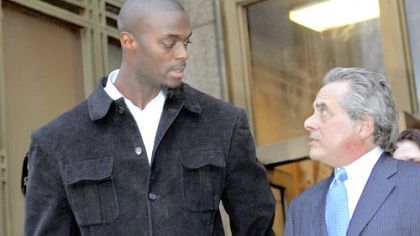 The Giants' Plaxico Burress, accompanied by his lawyer Benjamin Brafman, leaves Manhattan Supreme Court yesterday after his arraignment on weapons possession charges stemming from an incident at a Manhattan nightclub Friday.
