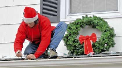 A volunteer crew from Elf Entertainment decorates the North Huntingdon home of a Lepley family in a contest that chose the families of two soldiers stationed in Iraq for free holiday decorations.