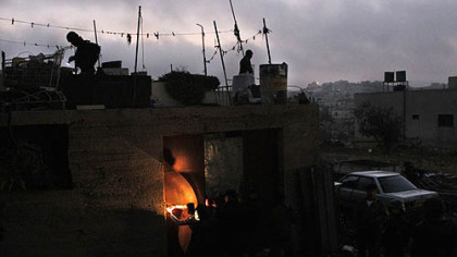PALESTINE -- Palestinian officers from a special security unit loyal to President Mahmoud Abbas enter a house during a raid searching for illegal weapons in the West Bank village of Samua near Hebron early Oct. 27. Nearly 600 troops of the Palestinian security forces deployed in the Hebron area early Saturday, as part of President Mahmoud Abbas' program to strengthen his control over the West Bank.