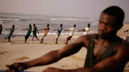 ACCRA, Ghana -- Fishermen haul in a net together in the community of Chorkor. That morning's catch was mainly garbage, swept into the sea by rains last week.